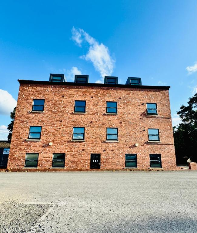 a brick building with four windows on the top at Private room - Shared Bathroom, Wakefield in Wakefield