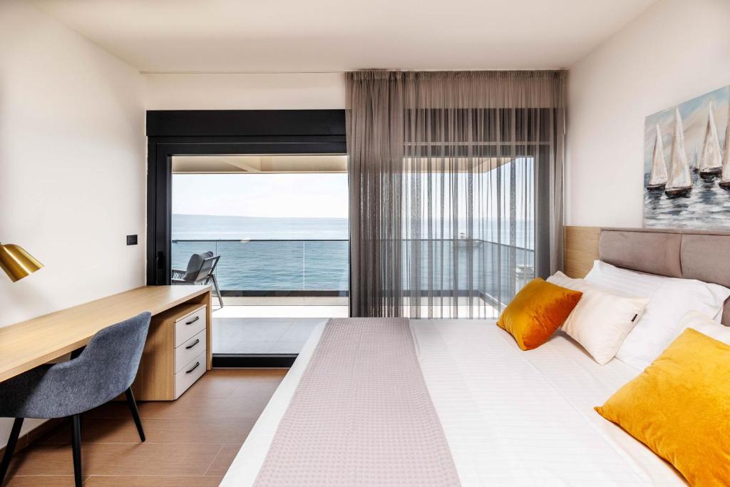 a bedroom with a bed and a desk and a window at Stella Maris in Podstrana