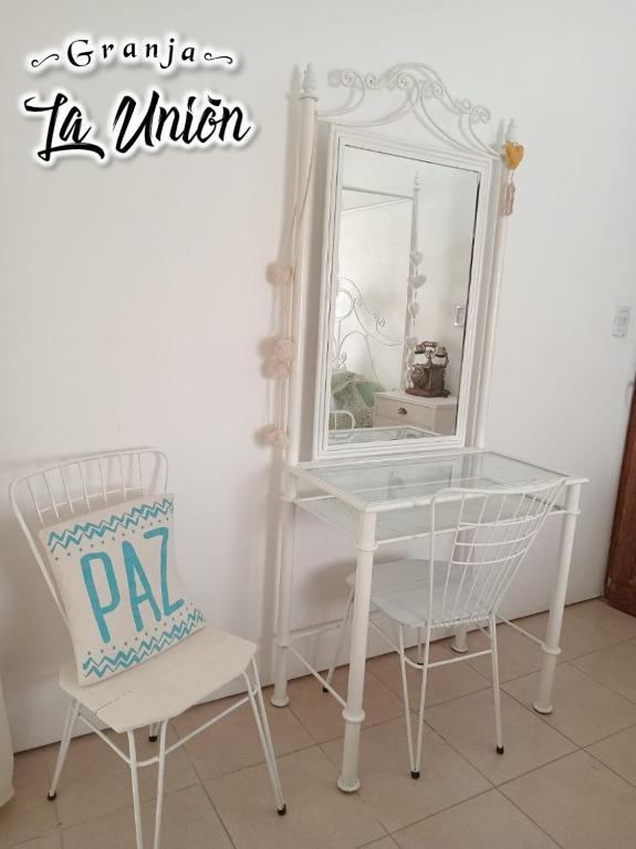 a white table and a chair and a mirror at Granja La Unión in Villa Dolores