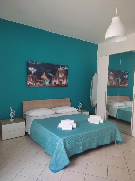 a blue bedroom with a bed and a blue wall at Kamurria House in Catania