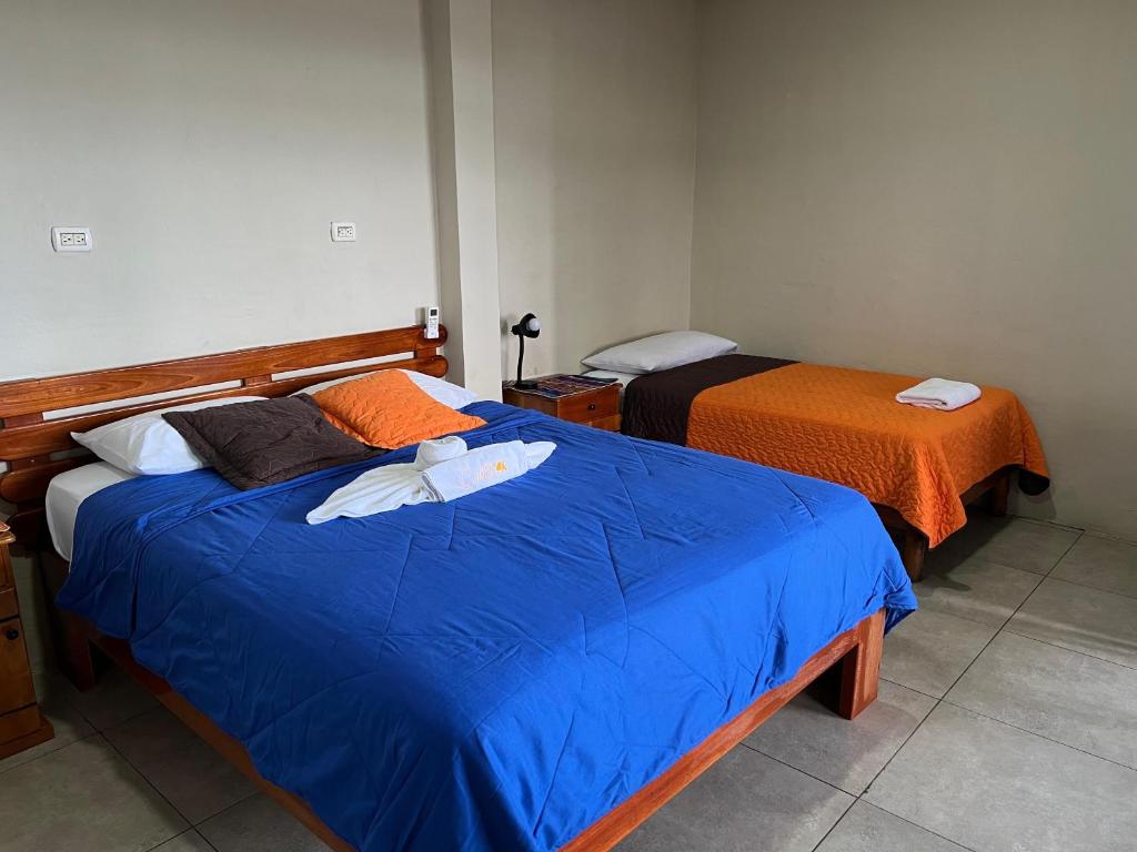 Postel nebo postele na pokoji v ubytování Hostal Cattleya