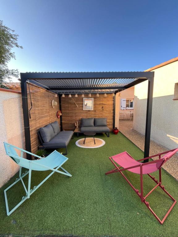d'une terrasse avec 2 chaises et un canapé sur gazon. dans l'établissement Villa T3 - 6 couchages - Piscine-Clim-Wifi-Garage, à Saint-Cyprien