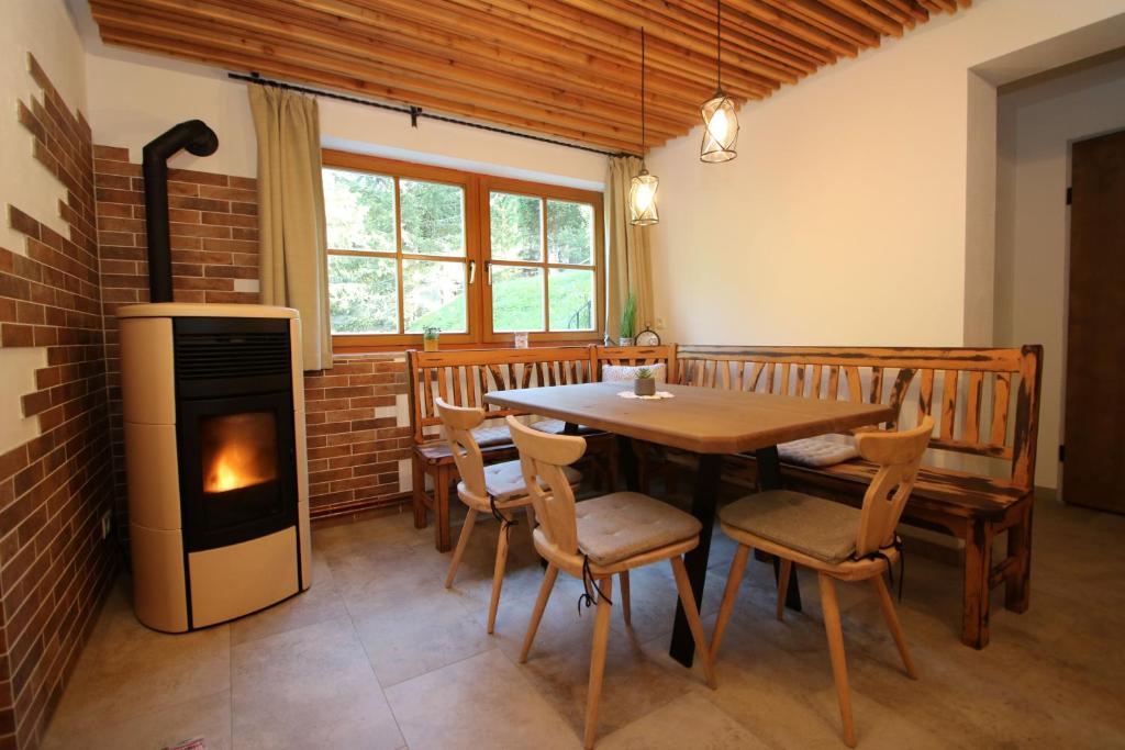een eetkamer met een tafel en een open haard bij Ferienwohnung Zirbenzapfen - Auszeit in den Seetaler Alpen in Judenburg