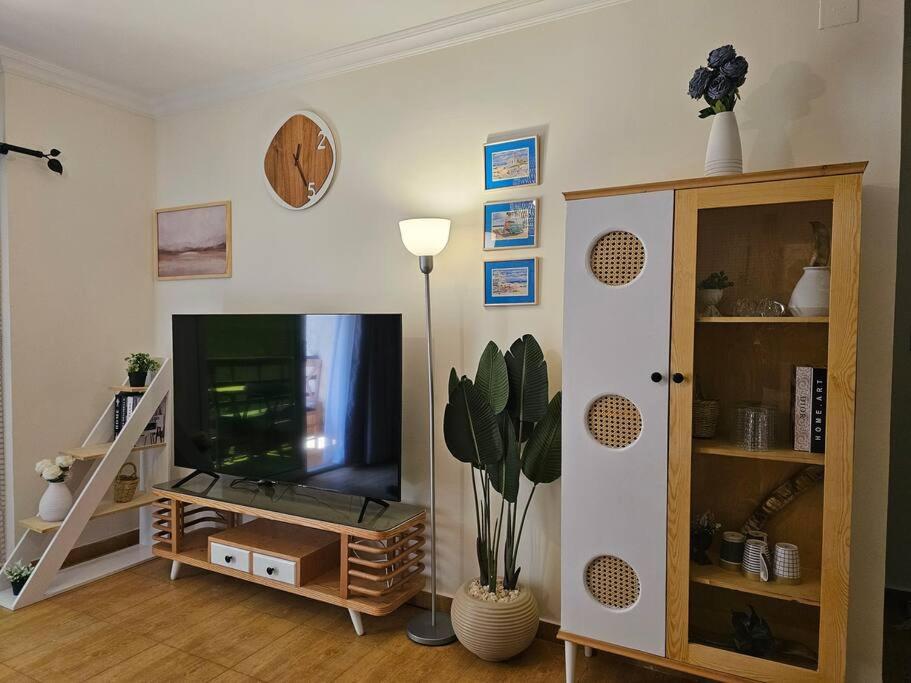 a living room with a flat screen tv and a shelf at Heaven with wide view garden in Madinaty