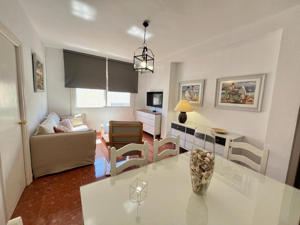 a kitchen and living room with a white table and chairs at Luz, sol y arena in Rota