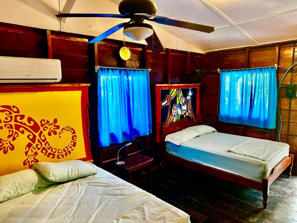 a bedroom with two beds and a ceiling fan at Coloso del Mar in Zancudo