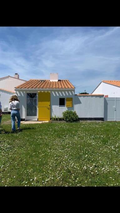 une personne debout dans une cour devant une maison dans l'établissement Petite Ferme Marine, à Bretignolles-sur-Mer