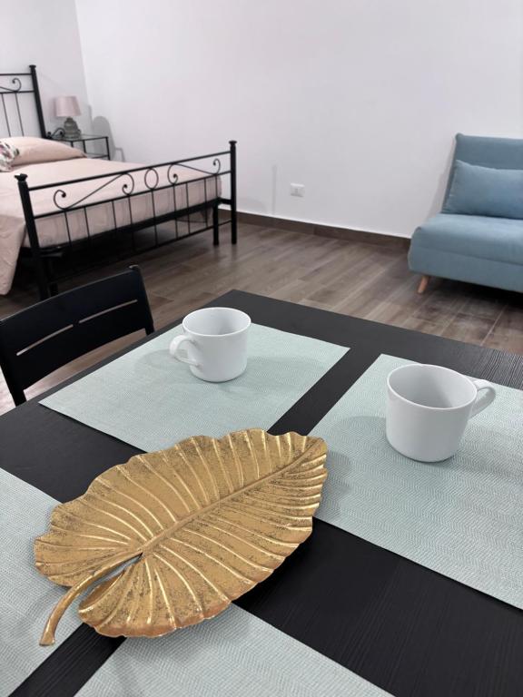 Una mesa con dos tazas y una hoja sobre ella. en Eccelsa 98, en Tívoli