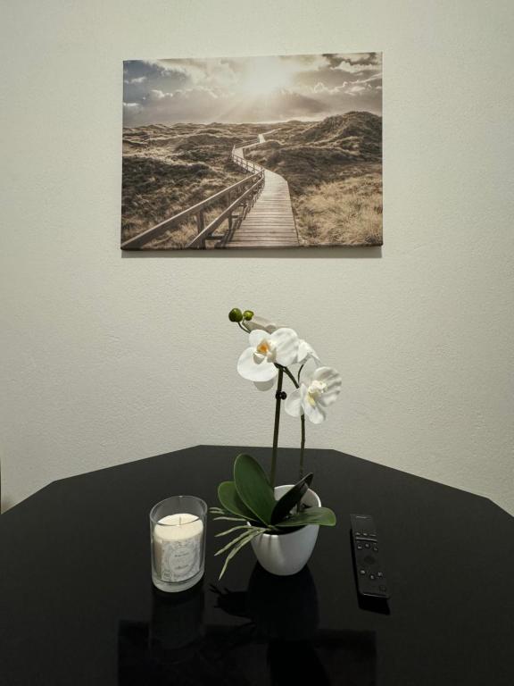 a vase with flowers on a table with a candle at City Ferien Wohnungen 2 in Rosenheim