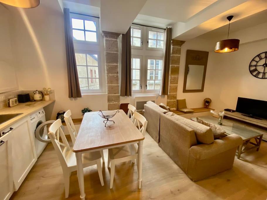 une cuisine et un salon avec une table et un canapé dans l'établissement Le standing du centre historique, à Périgueux