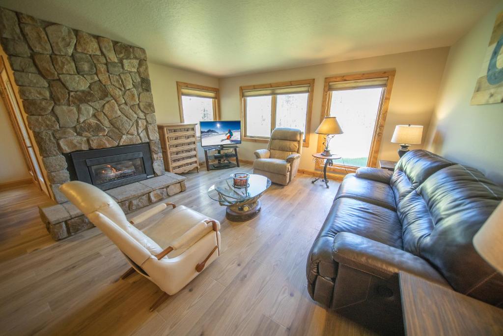 a living room with a couch and a stone fireplace at Quicksilver 1613 by SummitCove Lodging in Keystone