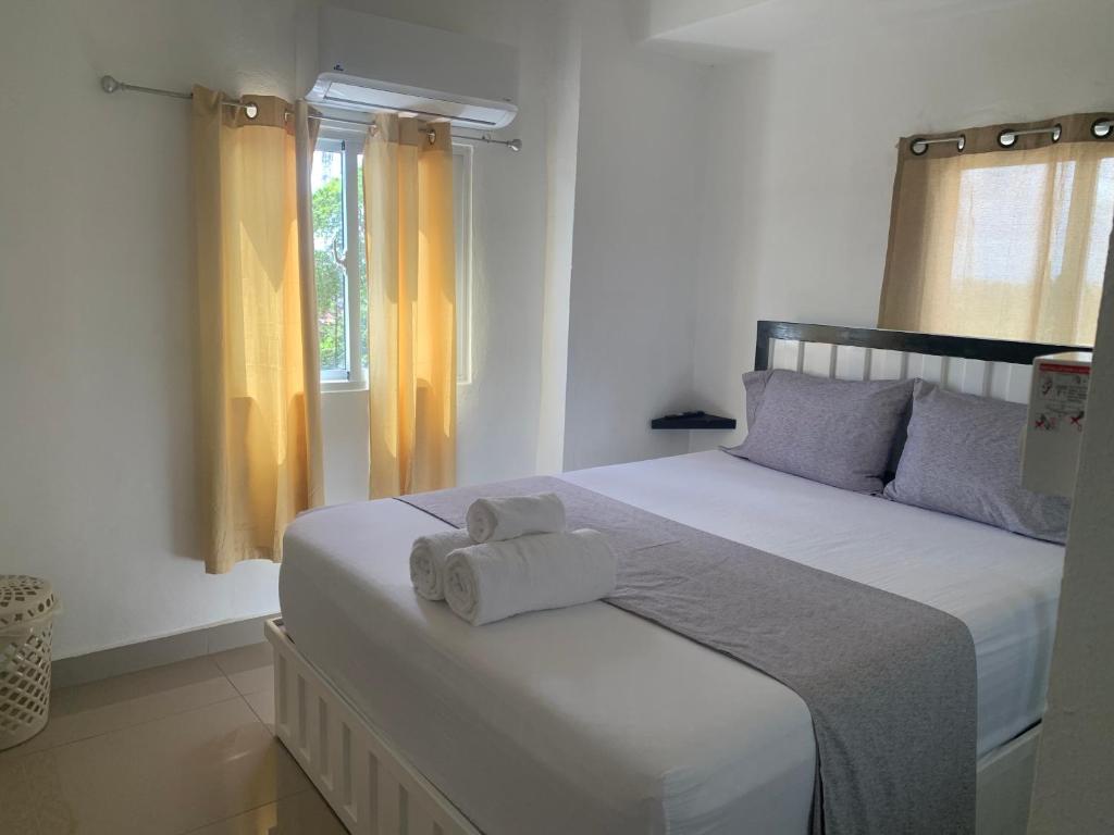 a bedroom with a bed with two towels on it at Plataview Apartahotel apt 4C in Monte Plata
