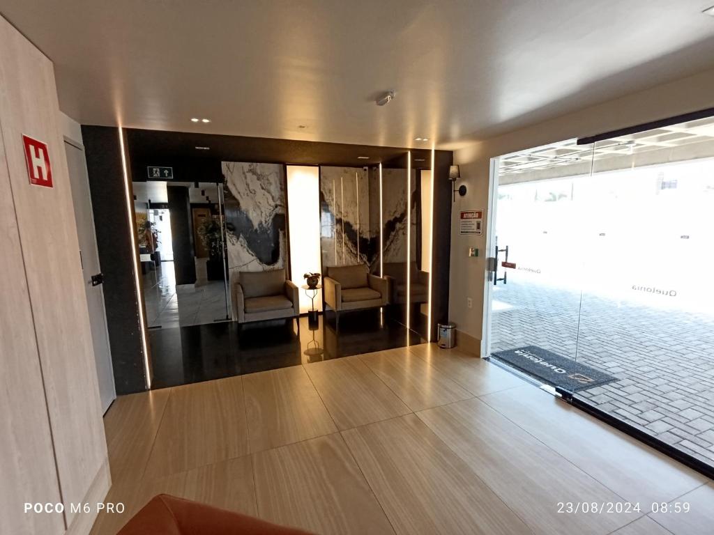 a lobby with two chairs and a glass door at Apto Praia Intermares Cabedelo Paraiba Q208 in Nossa Senhora do Livramento