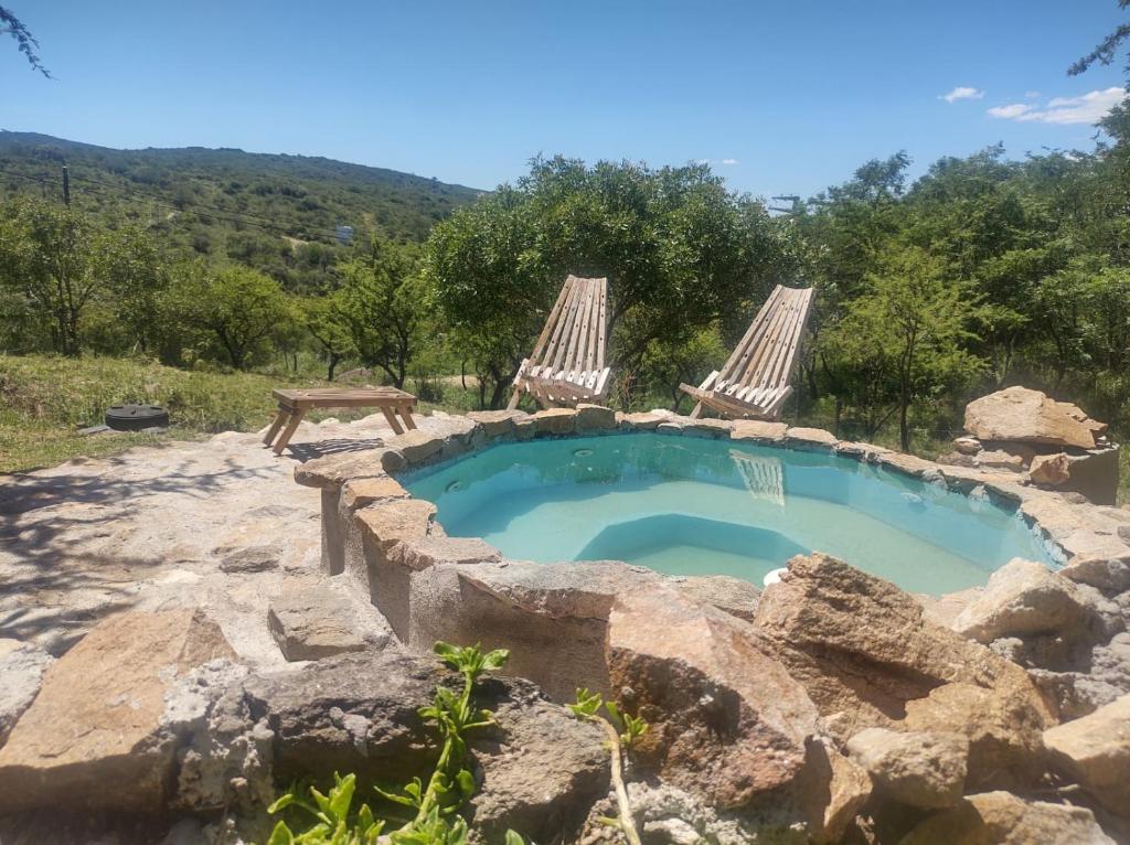 ein Felsenpool mit zwei Stühlen und einem Poolificialificialificialificialificialificialificial in der Unterkunft vistas del valle Cabaña in Valle Hermoso