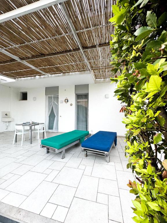 eine Terrasse mit zwei Bänken und einem Tisch in der Unterkunft Vento del mar Scirocco in San Cataldo