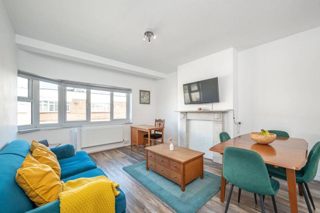 a living room with a blue couch and a table at 2BR Hendon Flat - Free Parking & Bus stop outside in Hendon