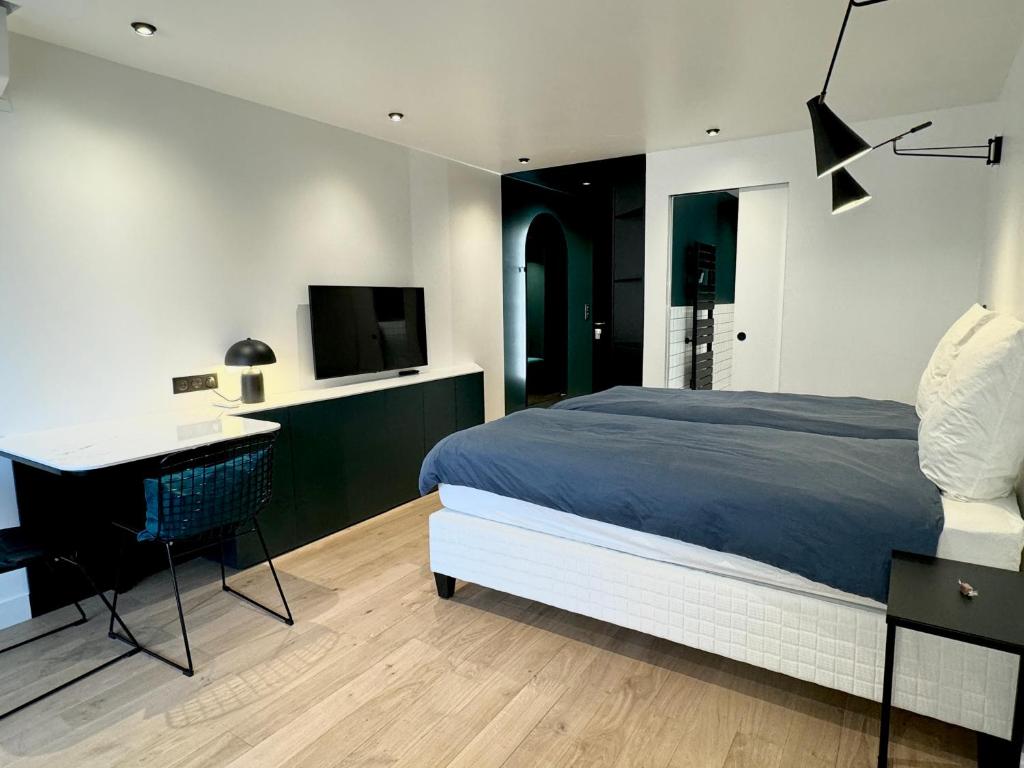 ビアリッツにあるVictoria Surf Studio d'Architecteのベッドと机とテレビのある寝室