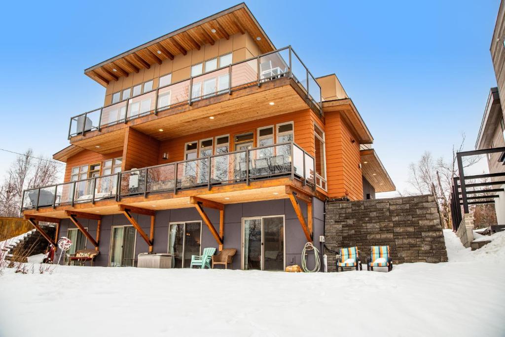 a wooden house with a balcony in the snow at Whitefish Lake Wonder in Whitefish