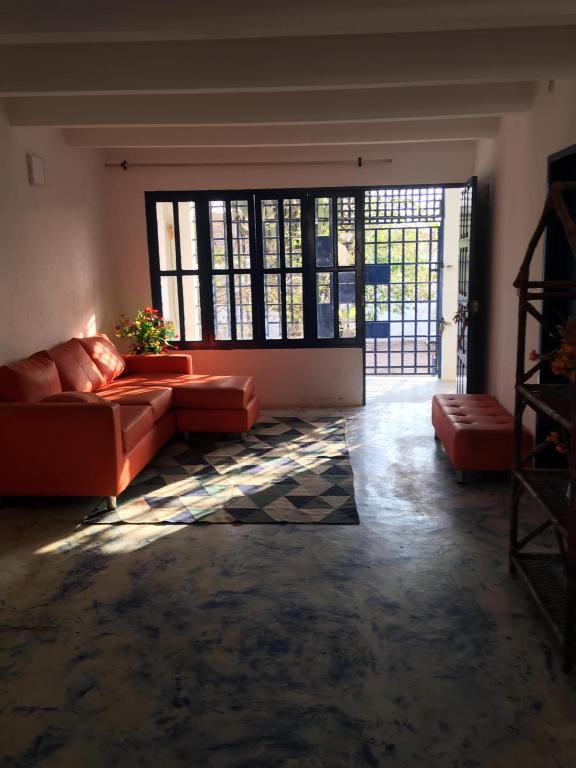 a living room with a couch and a large window at CASAMARAZUL Beach house in Santa Marta