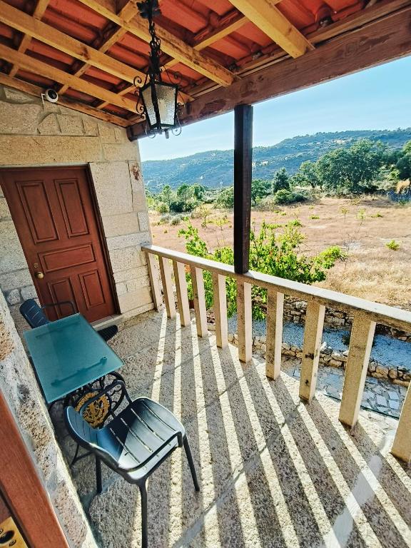 a patio with a table and a chair on a porch at Quinta das Amendoeiras in Meda