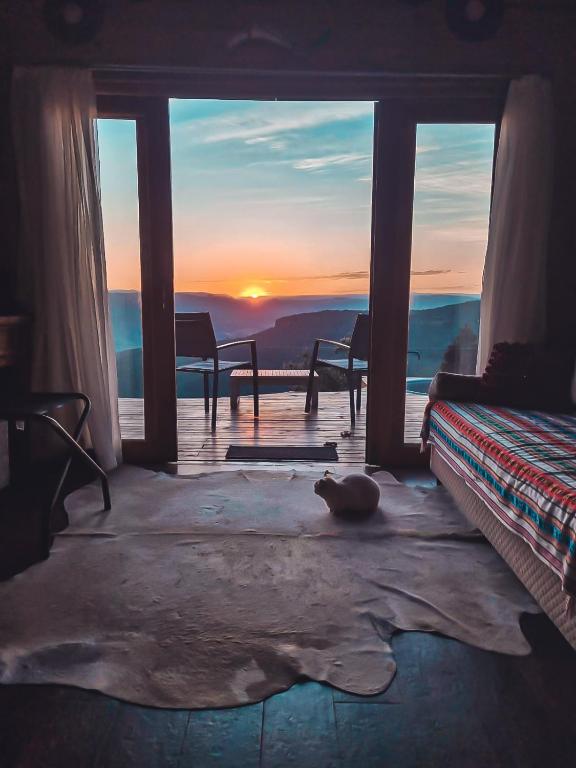 a room with a bed and a view of the sunset at Refúgio da Montanha Brasil in Alfredo Wagner