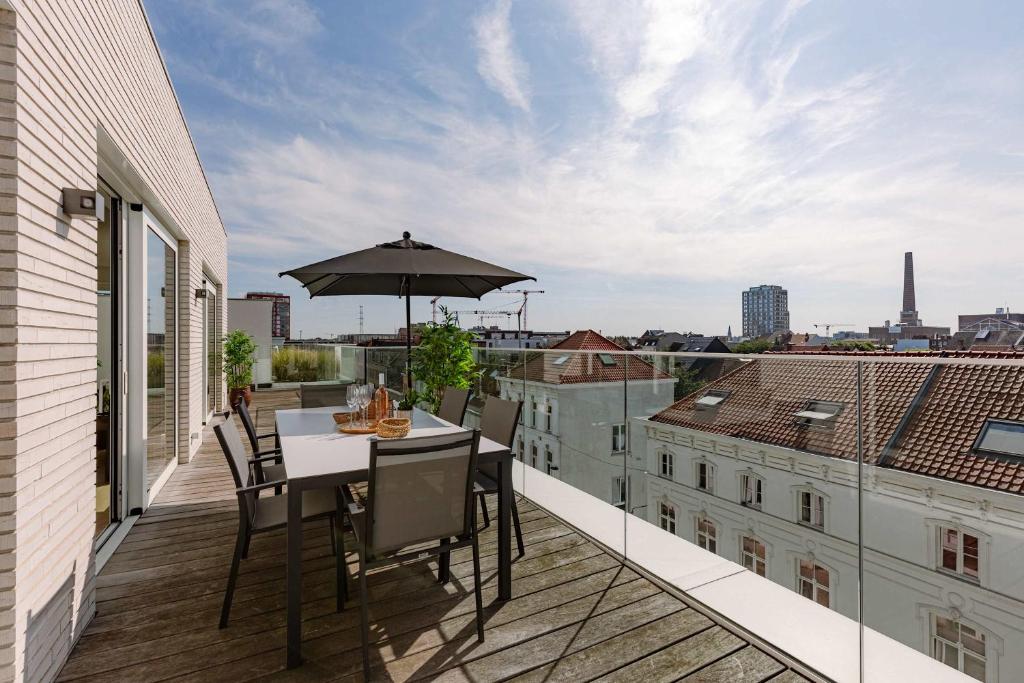 a balcony with a table and an umbrella at Huswell - Spacious apartment in Ghent with big terrace in Ghent