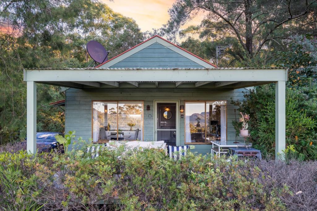 a small blue house with a porch at Martha's Villa - Panoramic, Peaceful Location in Kangaroo Valley