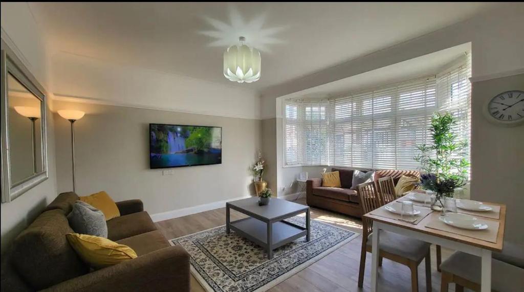 una sala de estar con un sofá y una mesa en Beautiful 4Bedroom 2Bath Wifi and Free Parking, en South Norwood