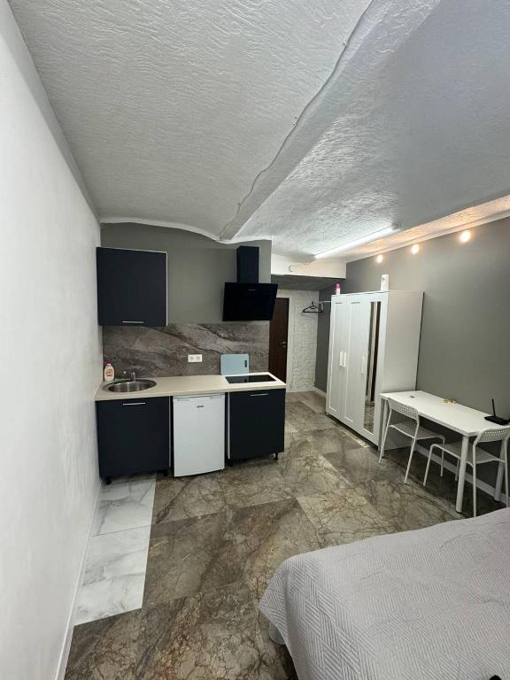 Habitación con cocina con cama y mesa. en Eksporta Appartaments, en Riga