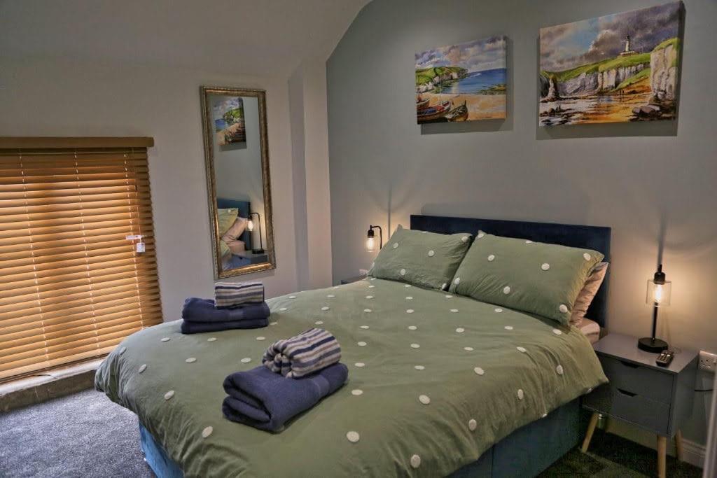 a bedroom with a bed with two towels on it at White Swan Cottage in Hunmanby