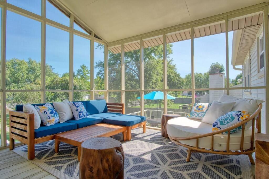 a screened in porch with a couch and chairs at Modern-Sunroom-15min to DwnTwn-Grps-Kids-Firepit in Indianapolis