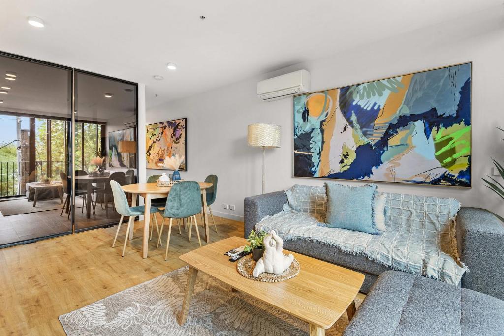 una sala de estar con un sofá y una mesa en Contemporary 1-Bed in the Heart of St Kilda, en Melbourne