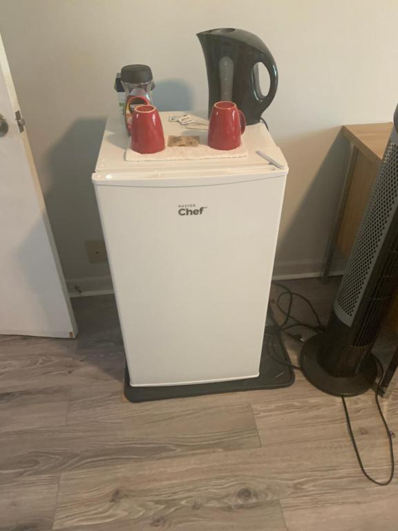 a small white refrigerator with two red cups on it at Montréal Steps Downtown Private Rooms in Montreal