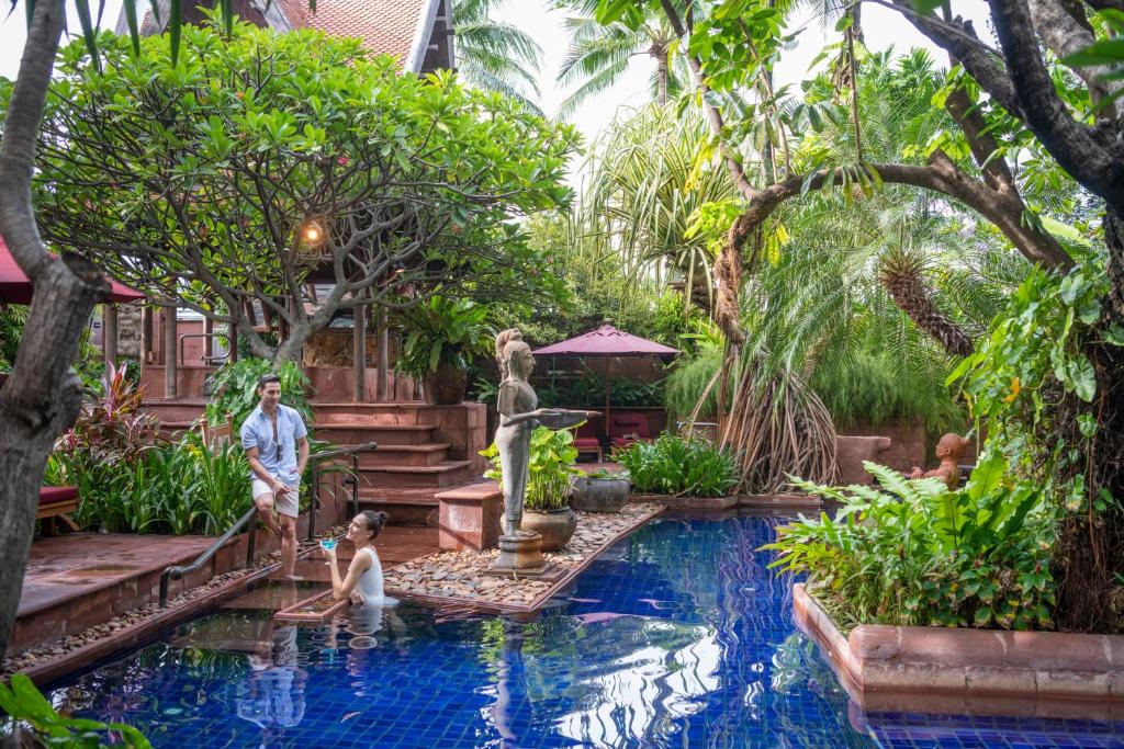 a group of people standing in a pool in a garden at Sheraton Grande Sukhumvit, a Luxury Collection Hotel, Bangkok in Bangkok