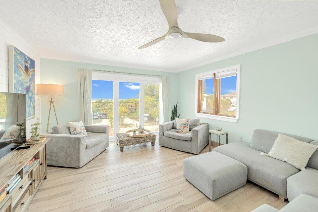 西耶斯塔岛Oceanview Penthouse, in VIllage, 30-steps to Best Beach, Tiki-Bar, Free Bikes and Paddle-boards!的有两张沙发和一台电视的客厅