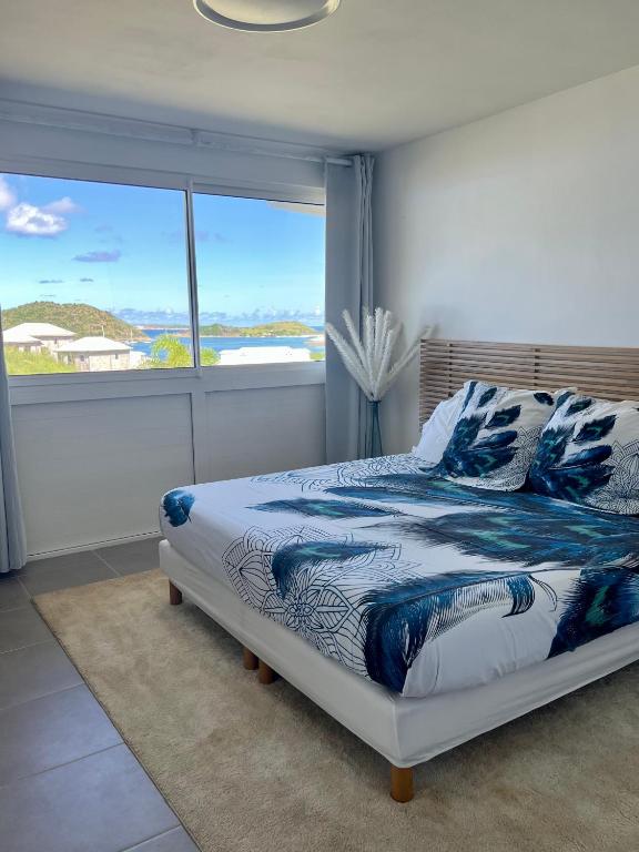 a bedroom with a bed and a large window at Appartement Sunrise in Cul de Sac