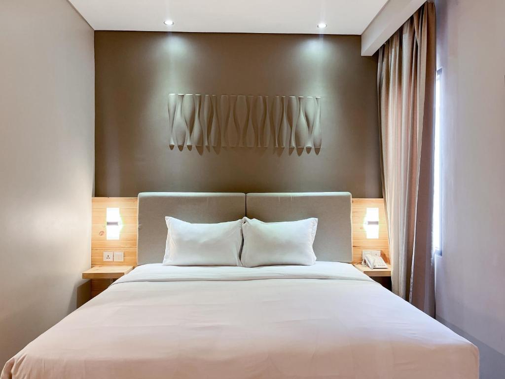 Postel nebo postele na pokoji v ubytování Verse Lite Hotel Gajah Mada