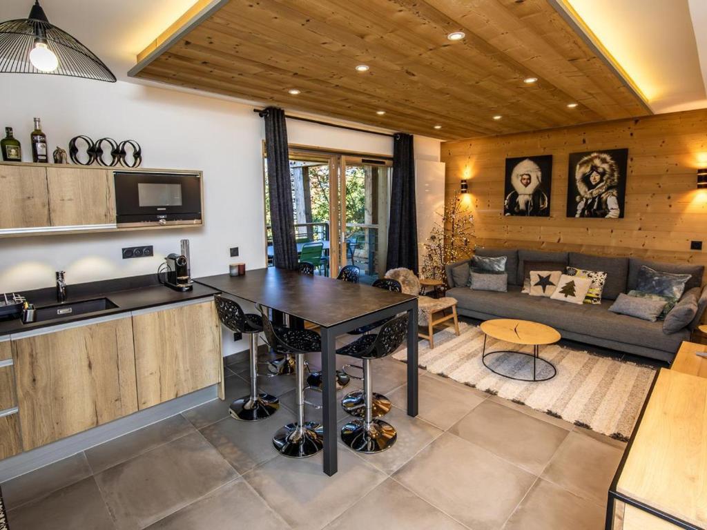 une cuisine et un salon avec une table et un canapé dans l'établissement Appartement de standing calme avec terrasse, espace bien-être et parking privé - FR-1-346-577, à Arc 1800