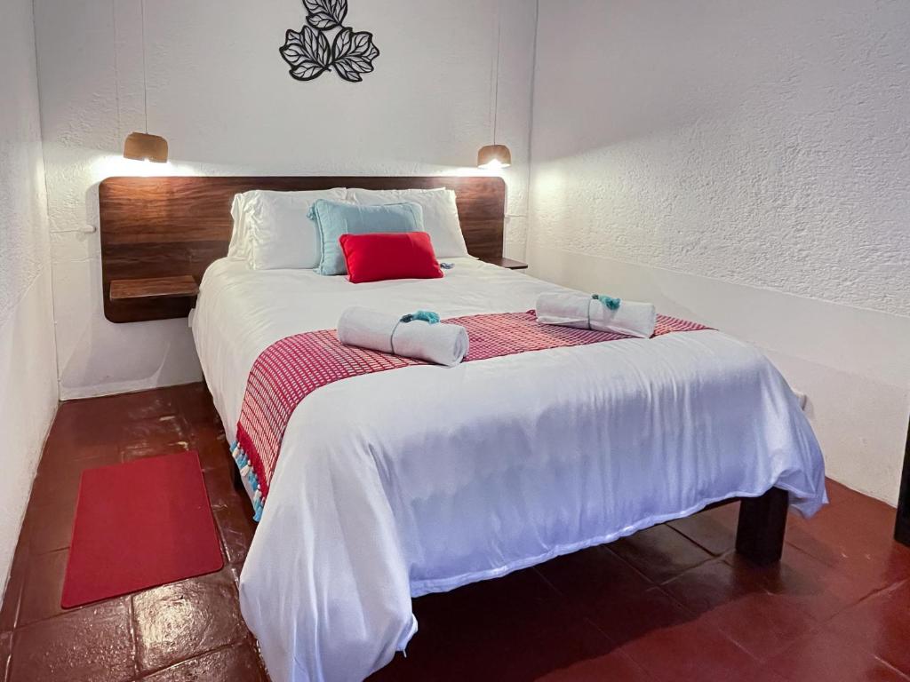 a bedroom with a large white bed with two towels on it at Villa Dulé in Antigua Guatemala