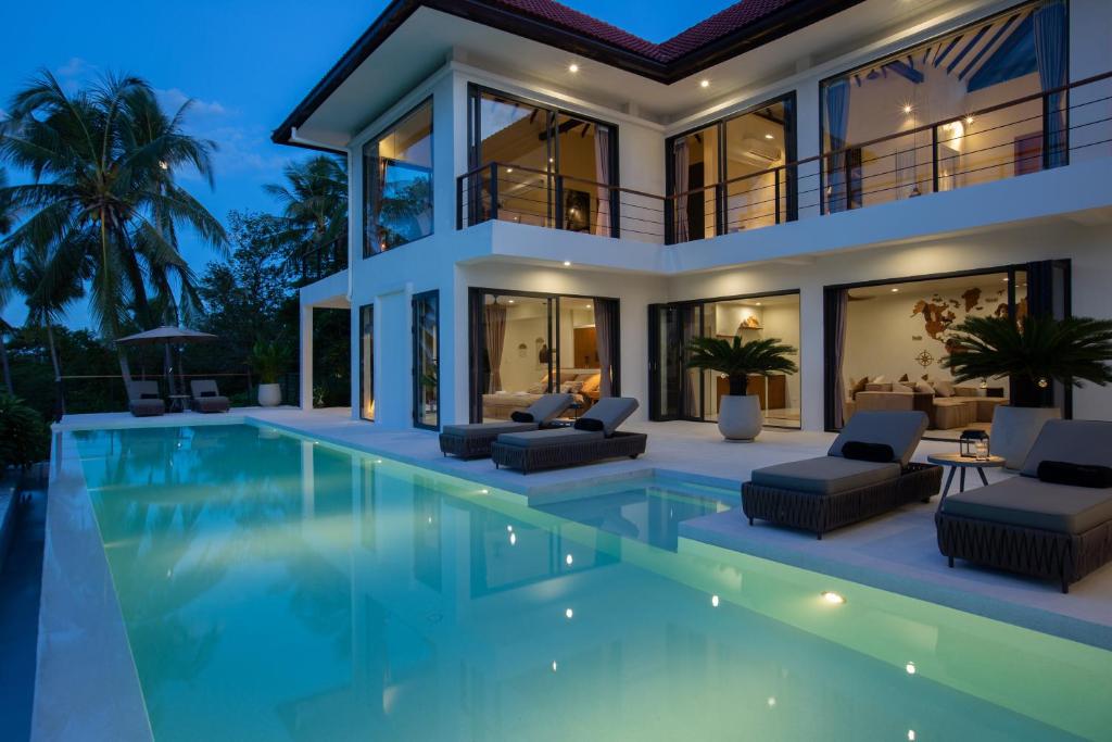 een villa met zwembad 's nachts bij Villa Nomada in Ban Bang Po