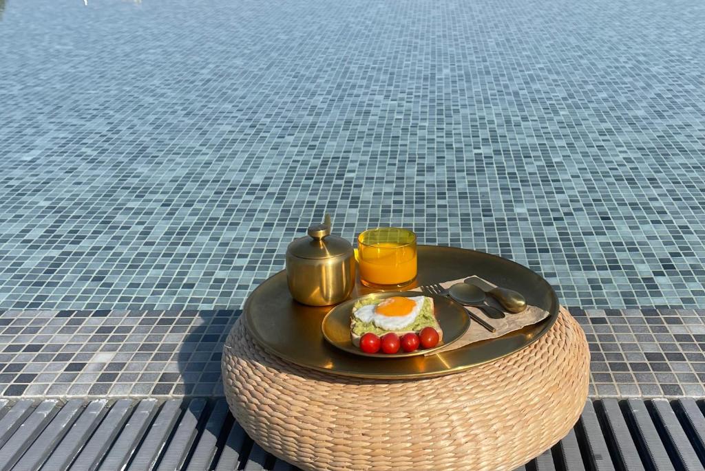 a breakfast tray with eggs and fruit on a table at Oikos Sani Suites in Sani Beach