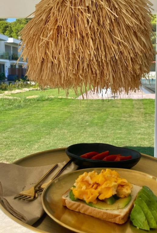a plate of food on a table with a plate of food at Oikos Sani Suites in Sani Beach