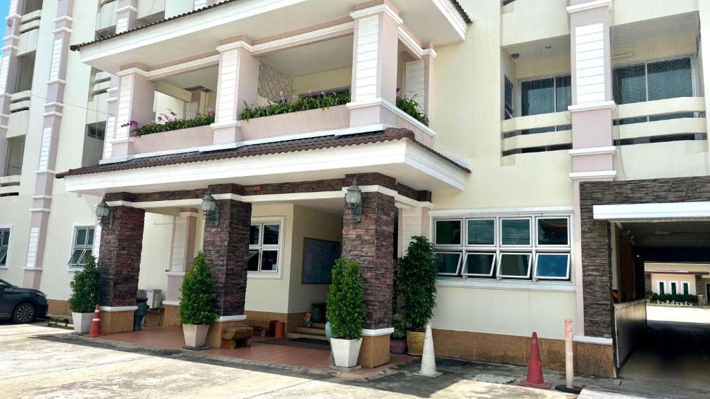 a building with potted plants in front of it at Fortune Surin Hotel in Surin