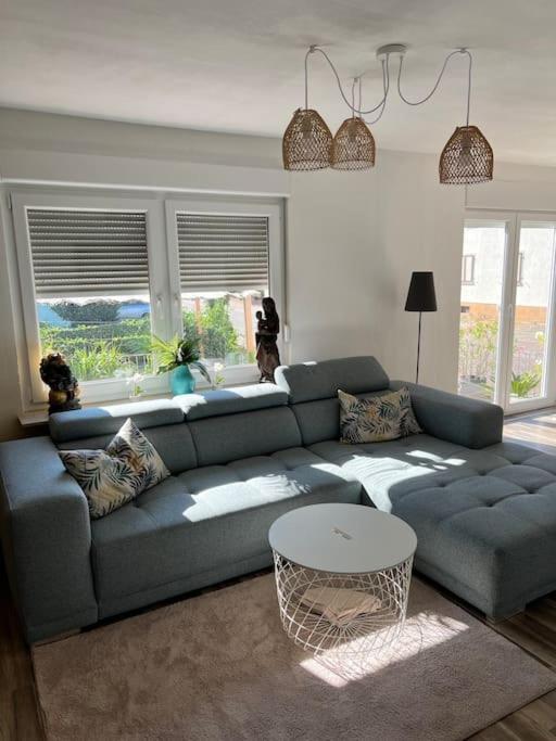 un salon avec un canapé bleu et une table dans l'établissement Design Apartment Bali in Rödersheim-Gronau, à Rödersheim-Gronau