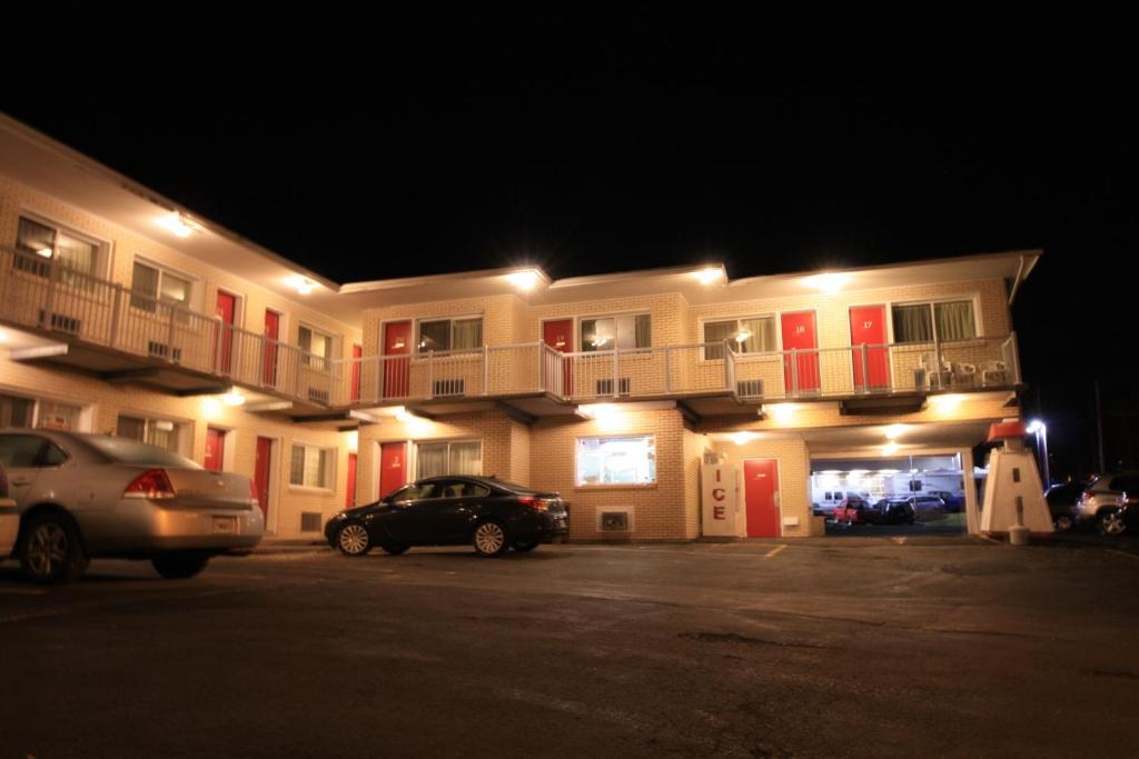 a large apartment building with a car parked in a parking lot at Lake City Motel in Halifax