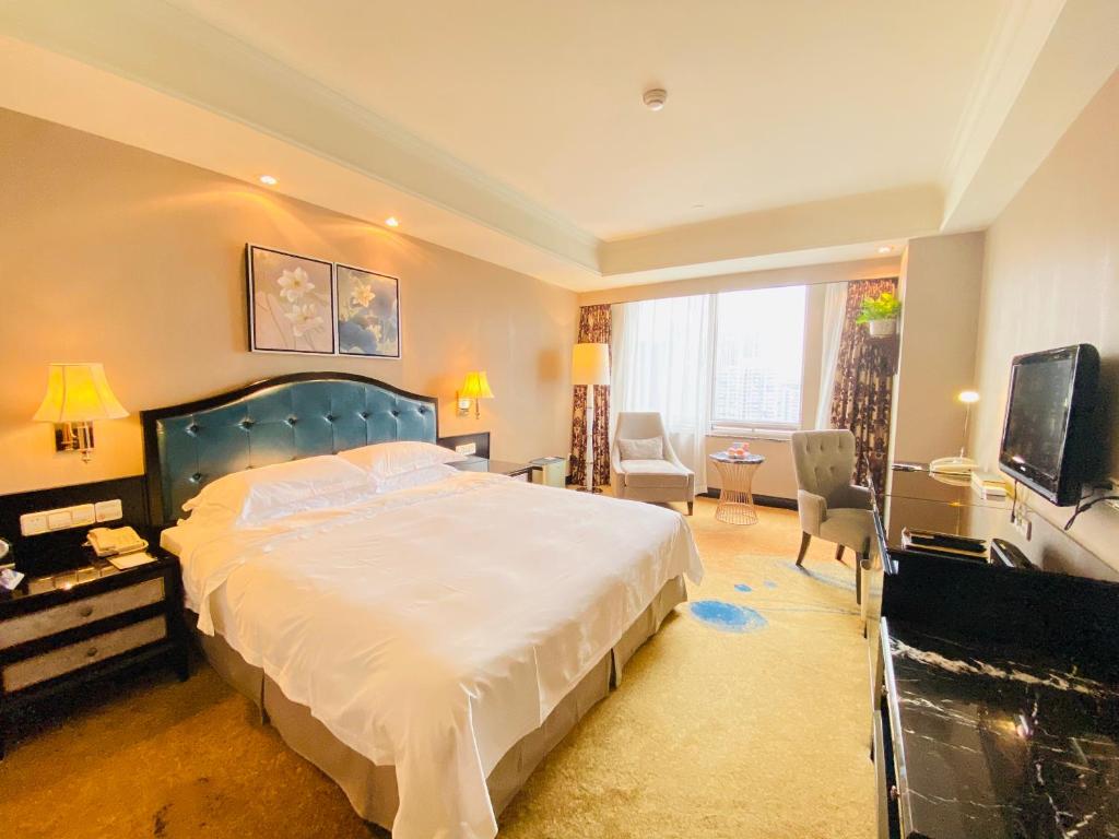 Postel nebo postele na pokoji v ubytování Ramada Plaza Tianlu Hotel
