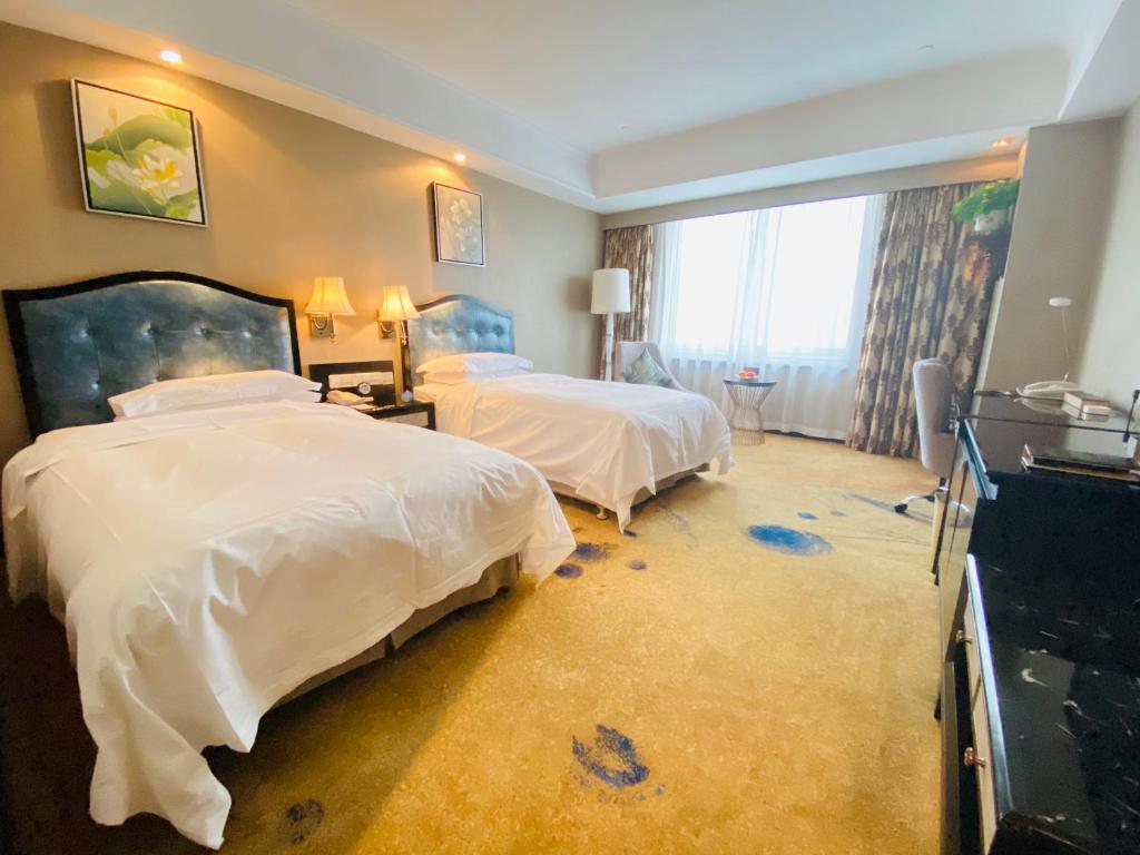 Postel nebo postele na pokoji v ubytování Ramada Plaza Tianlu Hotel