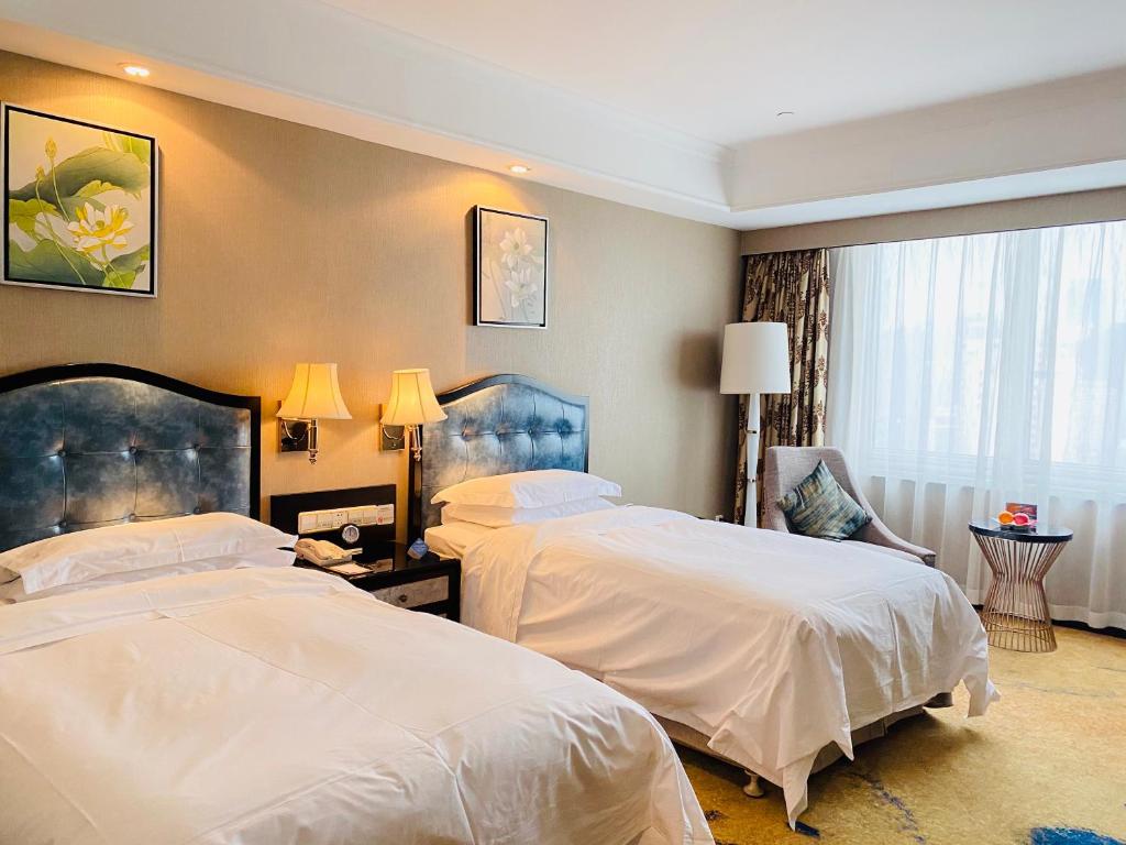 Postel nebo postele na pokoji v ubytování Ramada Plaza Tianlu Hotel