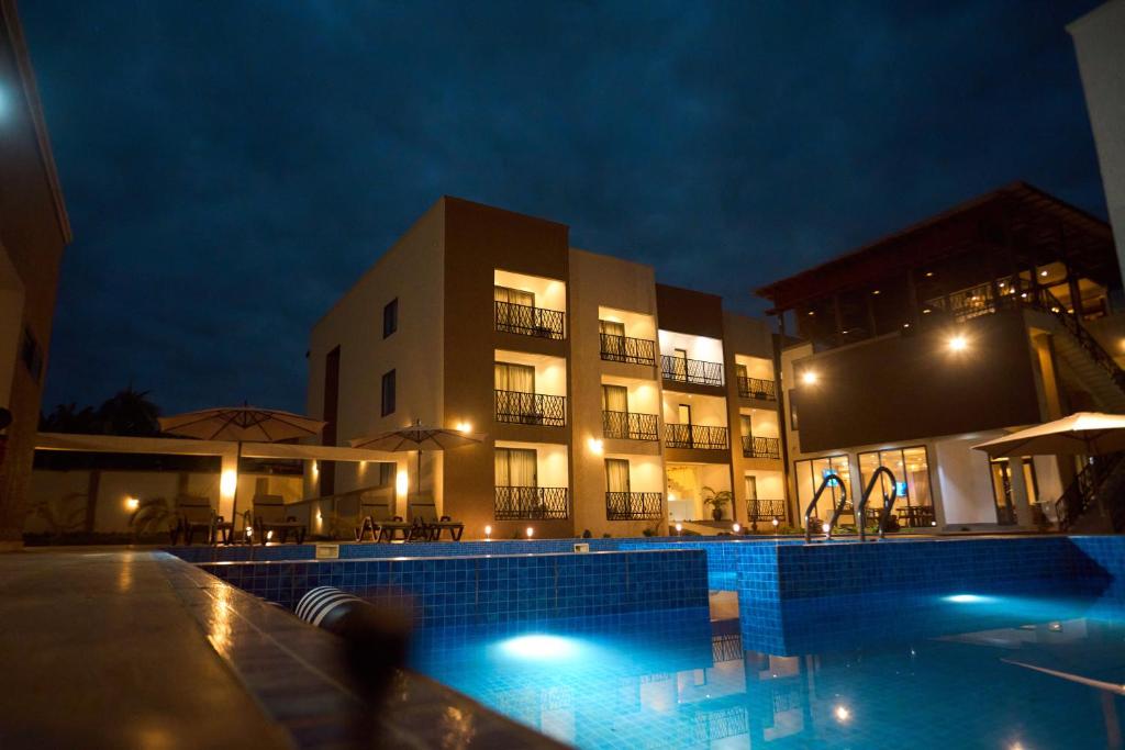 a building with a swimming pool at night at AIDEN HOMES AND APARTMENTS HOTEl in Koforidua