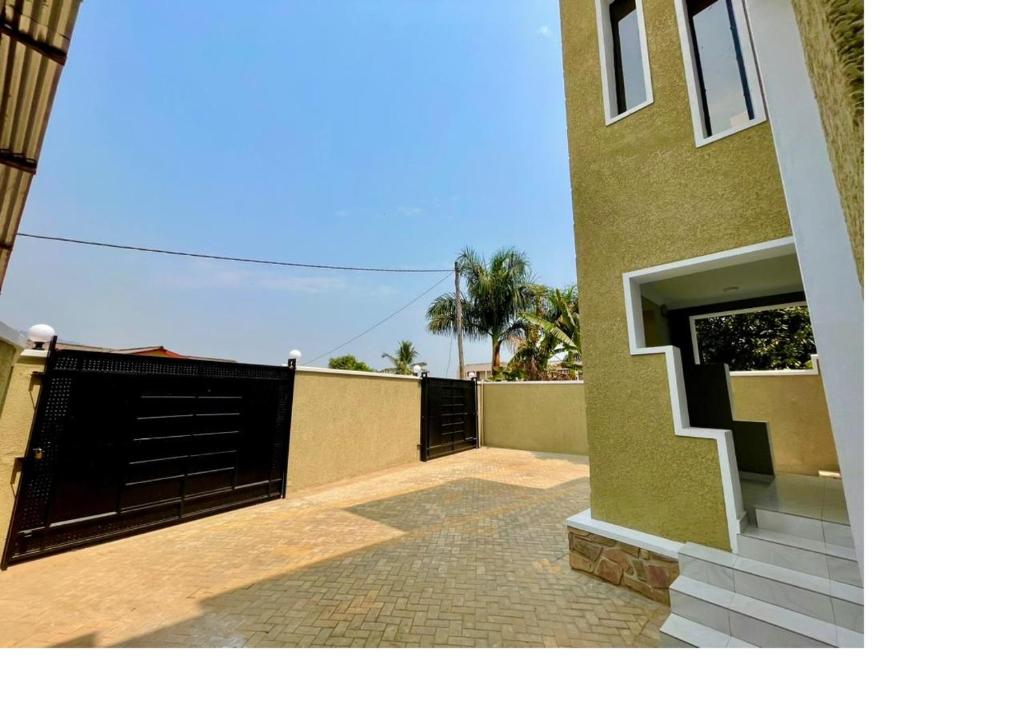 a house with a black gate and a brick walkway at BUJUMBURA Appart in Bujumbura
